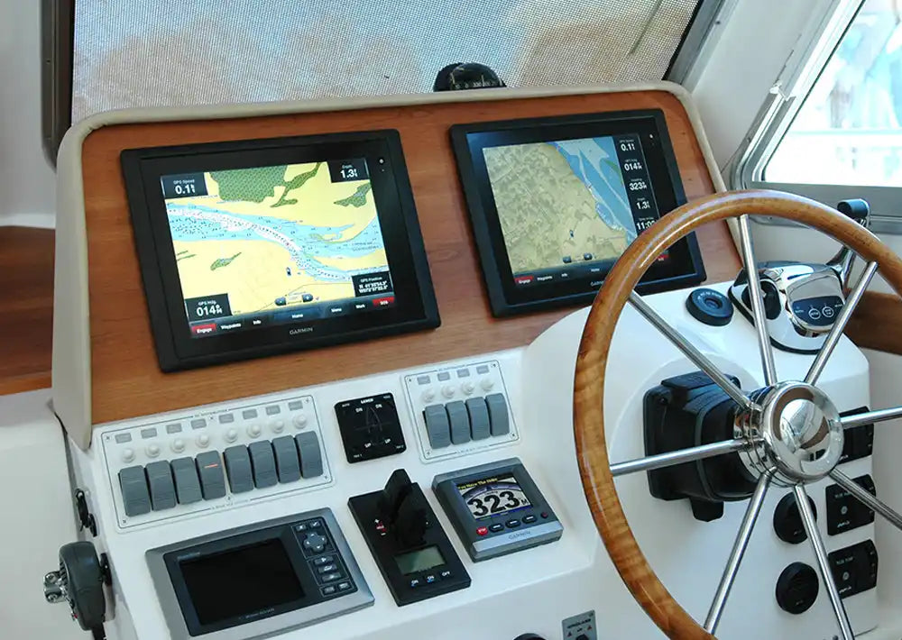 Modern boat helm station with dual navigation displays, controls, and a wooden steering wheel.