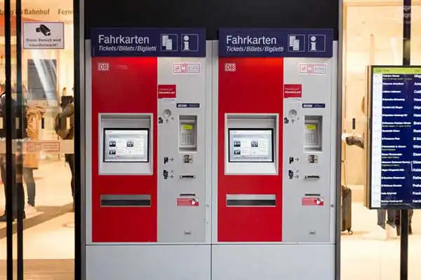 Two red Deutsche Bahn ticket vending machines mounted side by side.